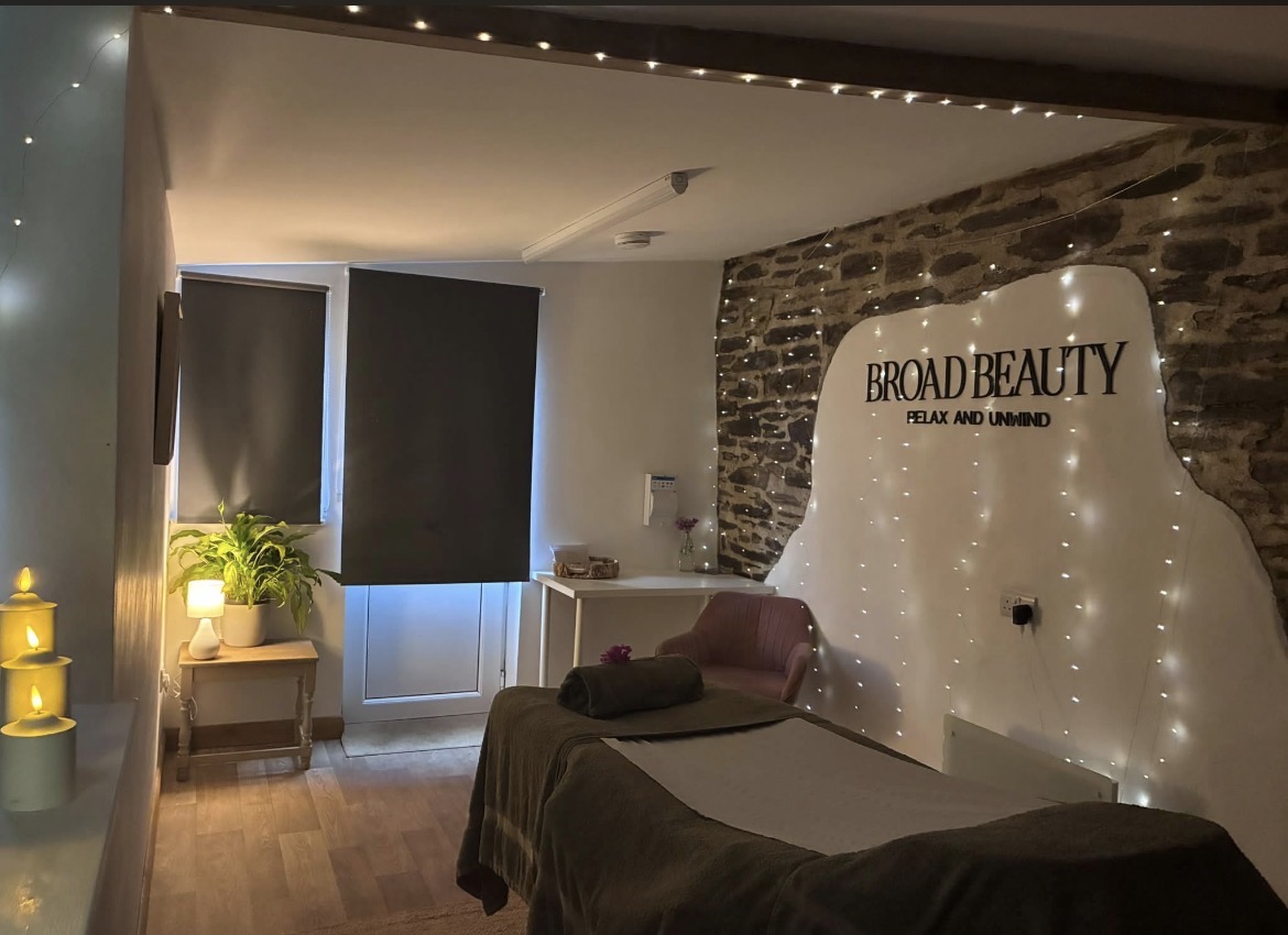 Broad Beauty salon with a massage bed, stone wall and warm lighting